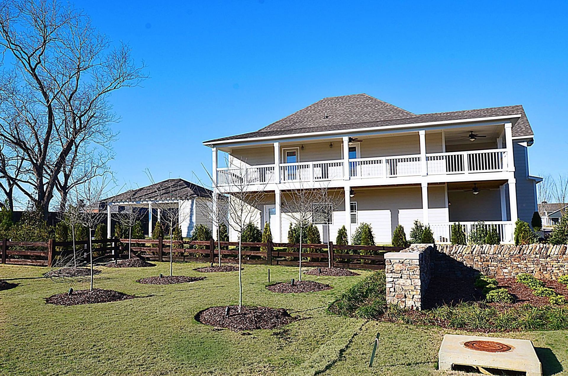 A large white house with a fire pit in front of it.