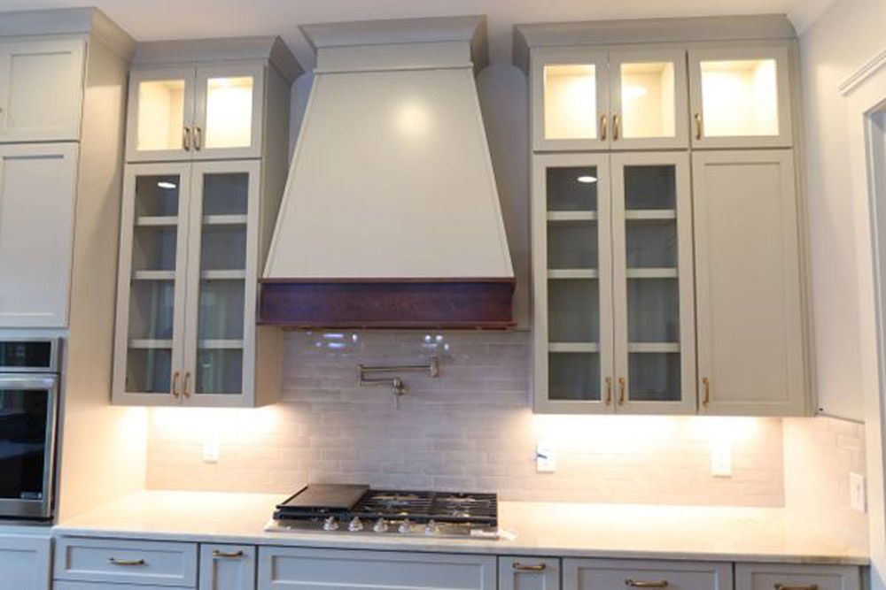 A kitchen with white cabinets and a stove top oven