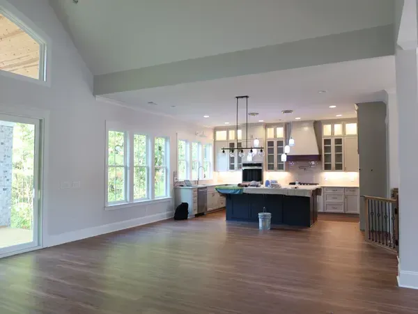 An empty kitchen with a large island in the middle of the room.