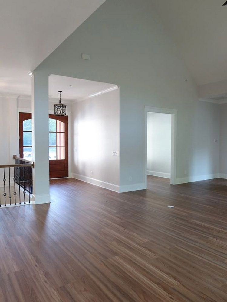 A large empty room with hardwood floors and white walls