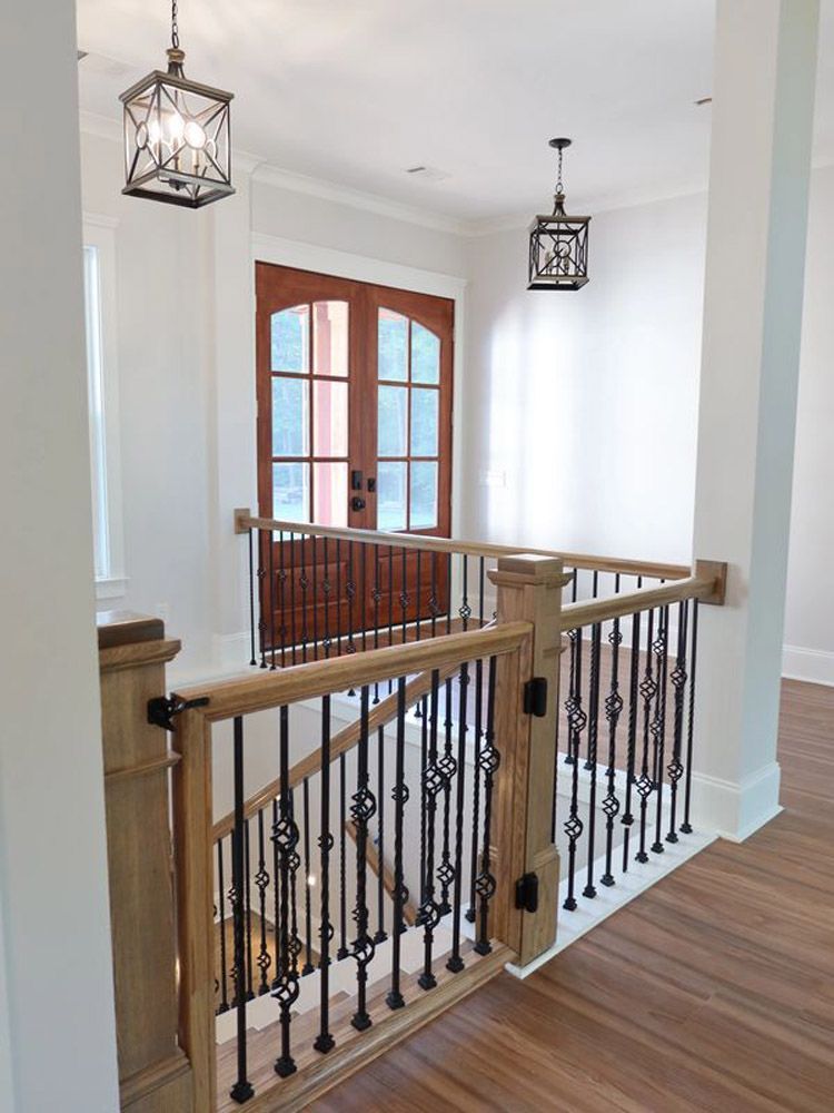 A staircase with a wooden railing and a wrought iron railing in a house.