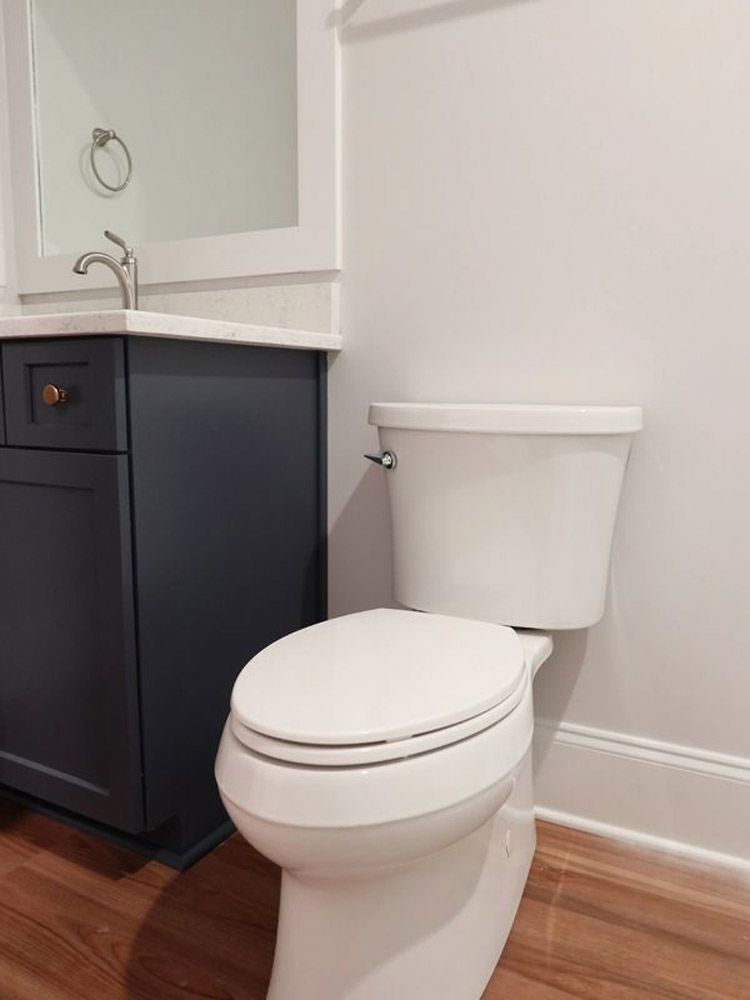 A bathroom with a toilet , sink and mirror