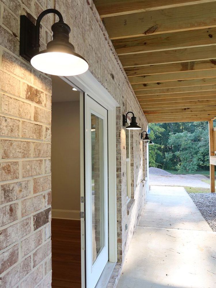 A brick wall with a white door and a light on it