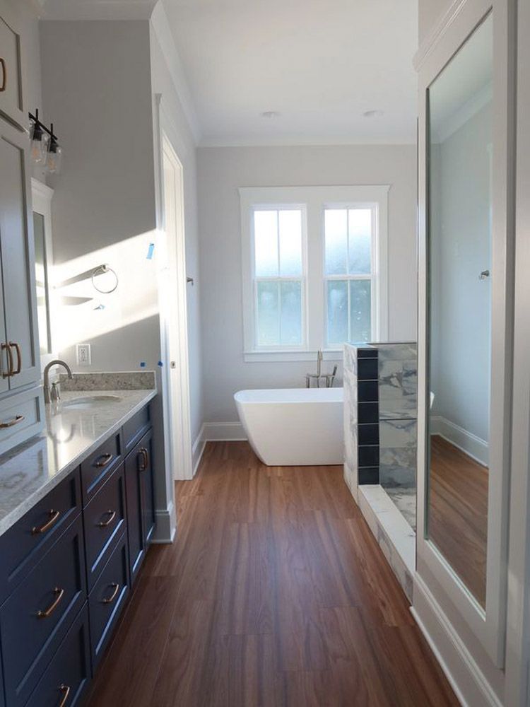 A bathroom with a tub , sink and mirror