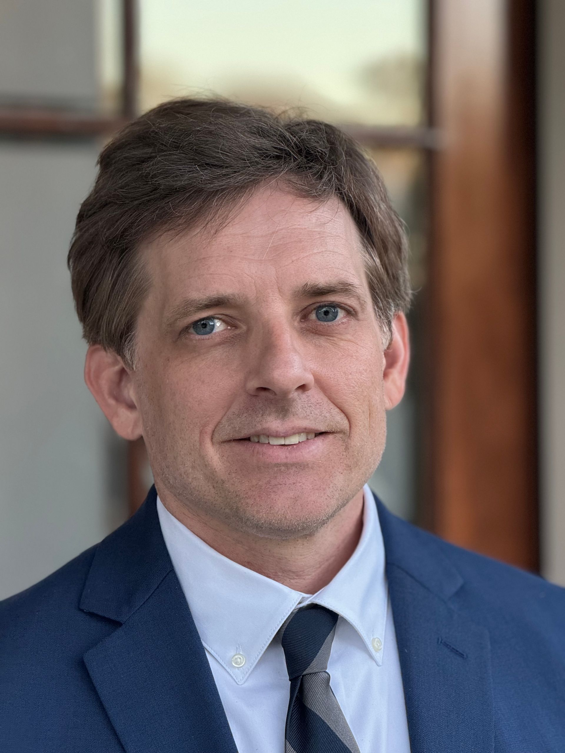 A man in a suit and tie is smiling for the camera.