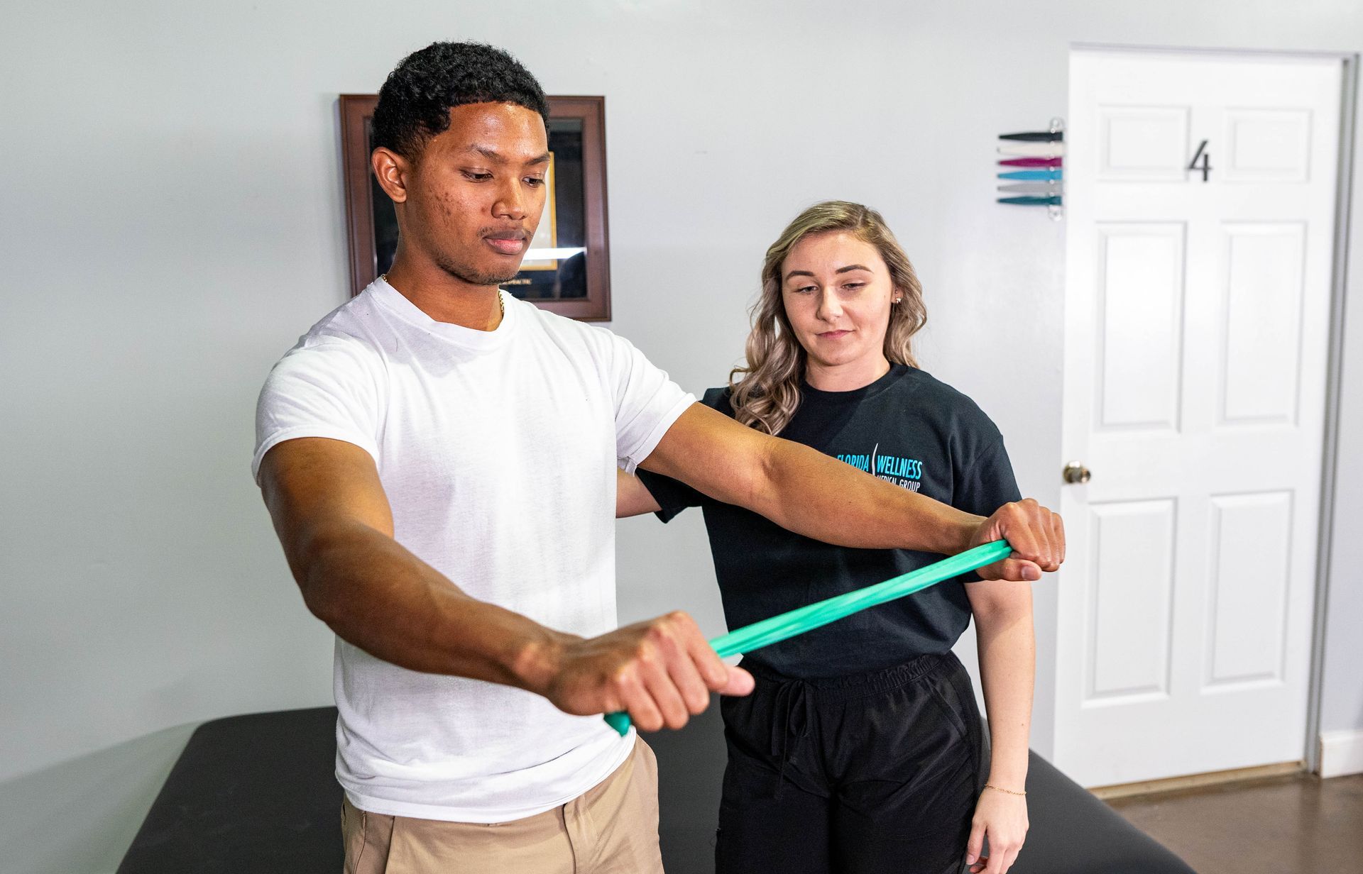 A man and a woman are doing exercises with a rubber band.