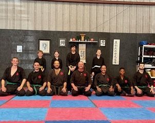 A Group Of People Are Sitting On A Mat In A Gym — St. Augustine, FL — Amp Hardcore Gym