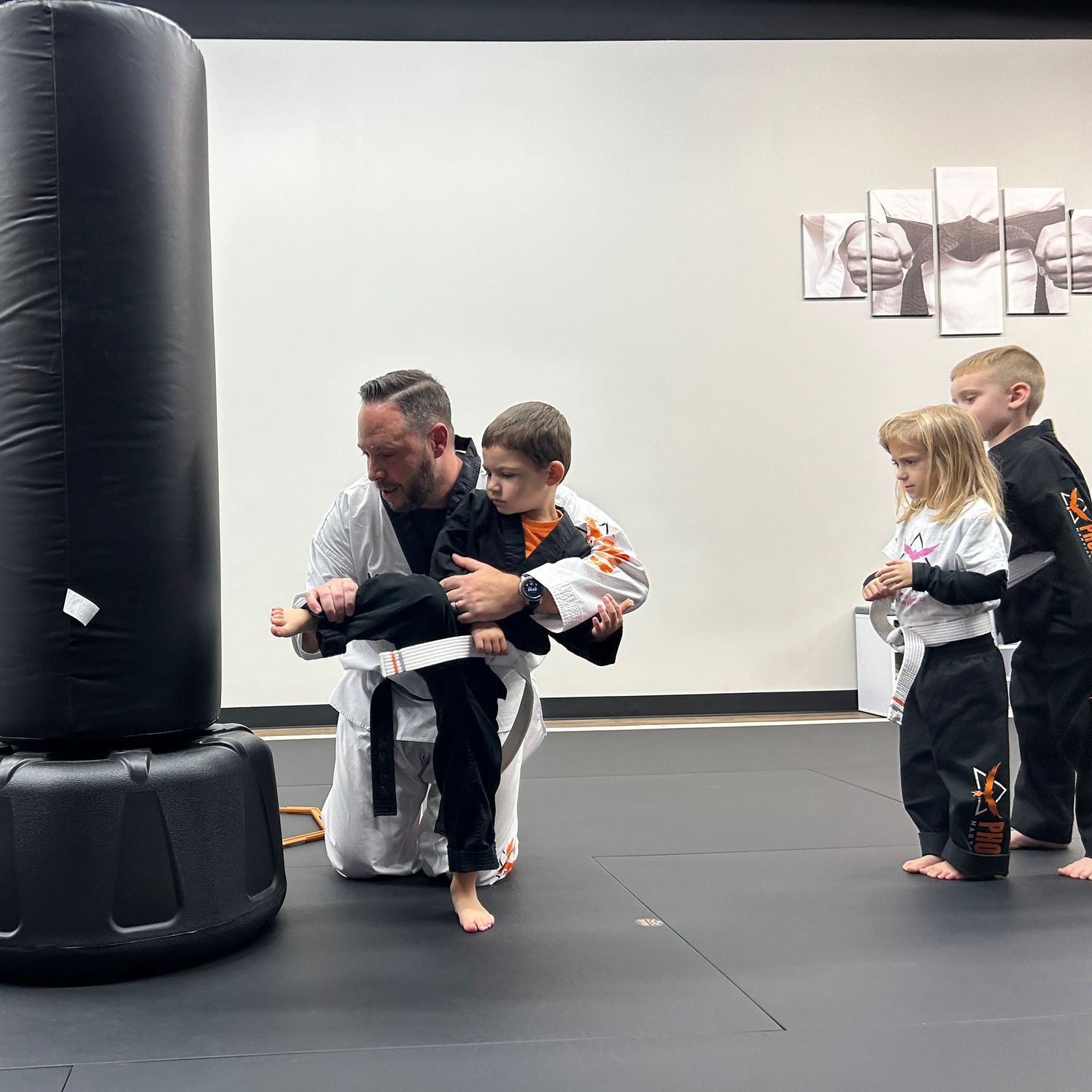 A man and a woman are practicing martial arts in a gym.