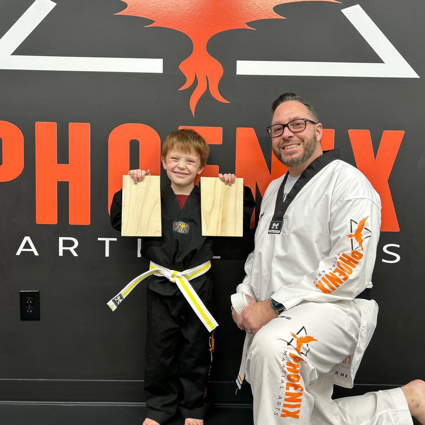 A man is teaching a woman how to box in a gym.