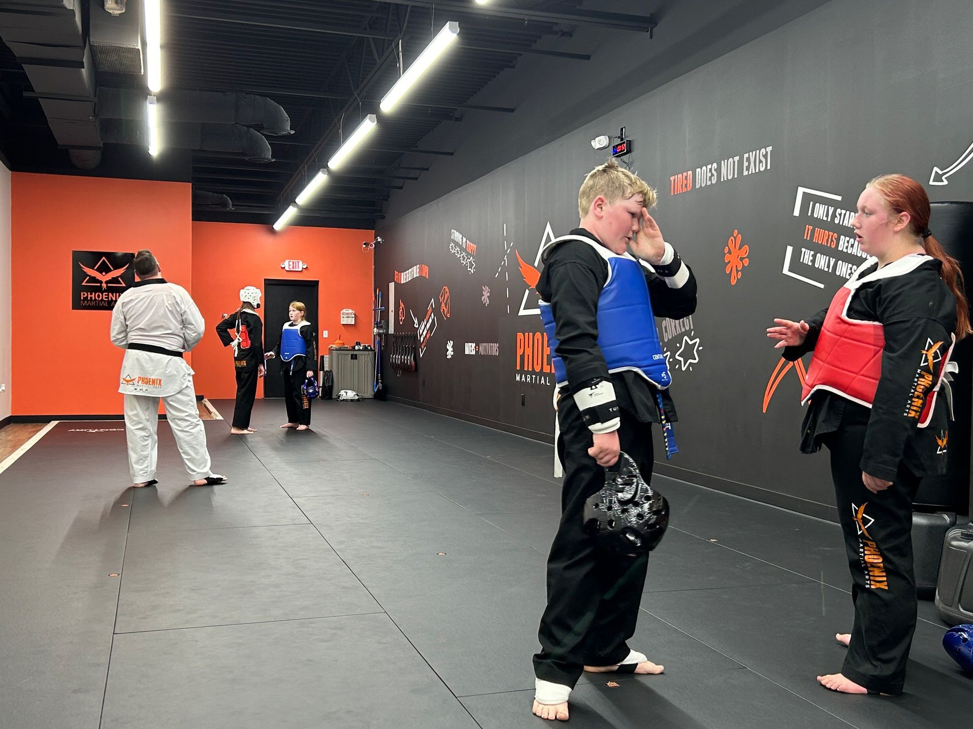 A group of people are practicing martial arts in a gym.