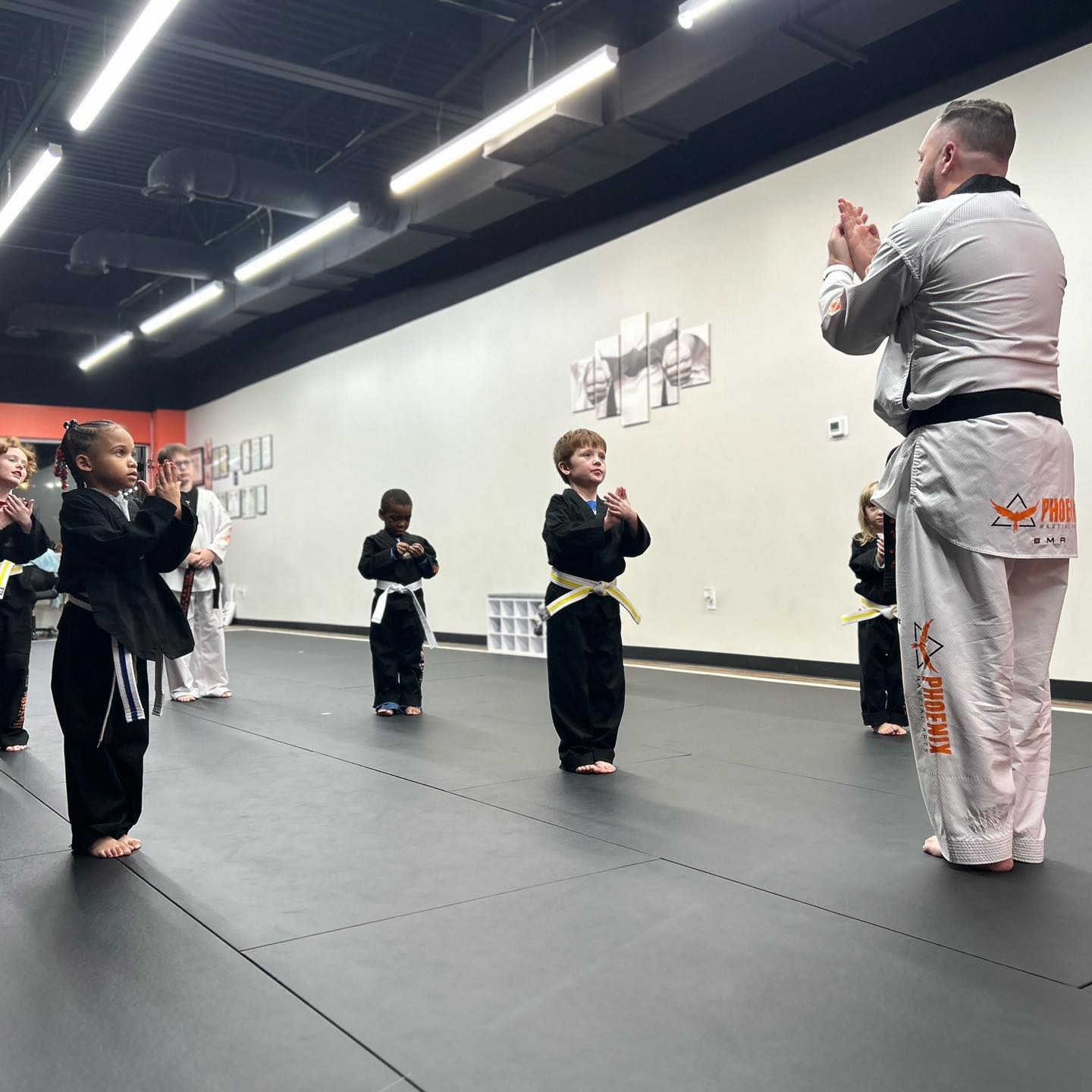 A group of young children are practicing martial arts in a gym.