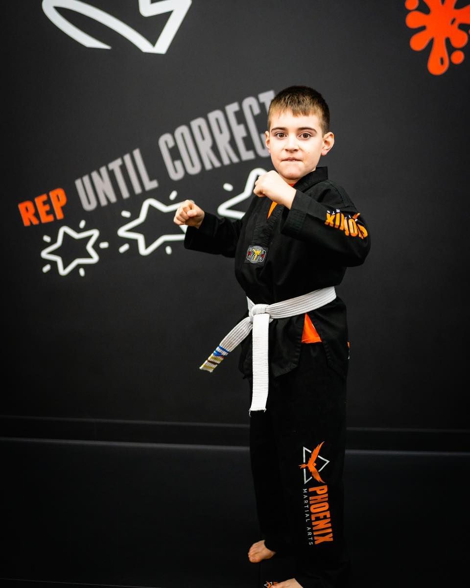 A man and a woman are wrestling on a mat in a gym.