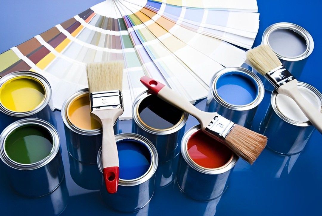 A Bunch Of Cans Of Paint And Brushes On A Table — Tweed Heads Painting Service In Condong, NSW