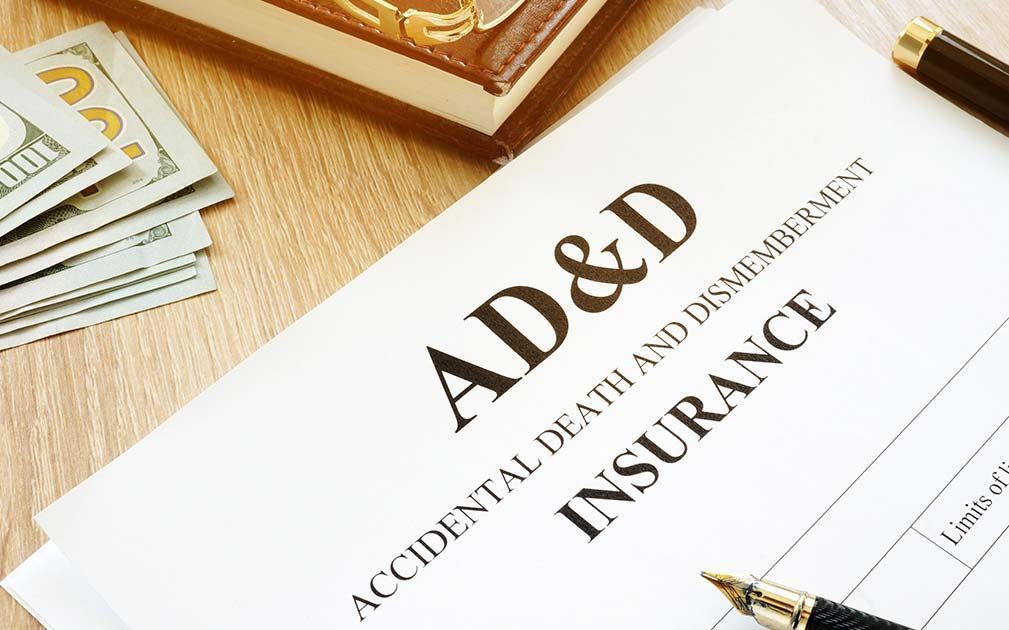 An ad and d insurance form with a pen and money on a table.