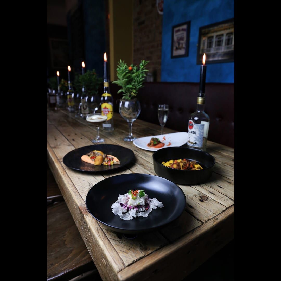 Table set with food and drinks in a dimly lit restaurant.
