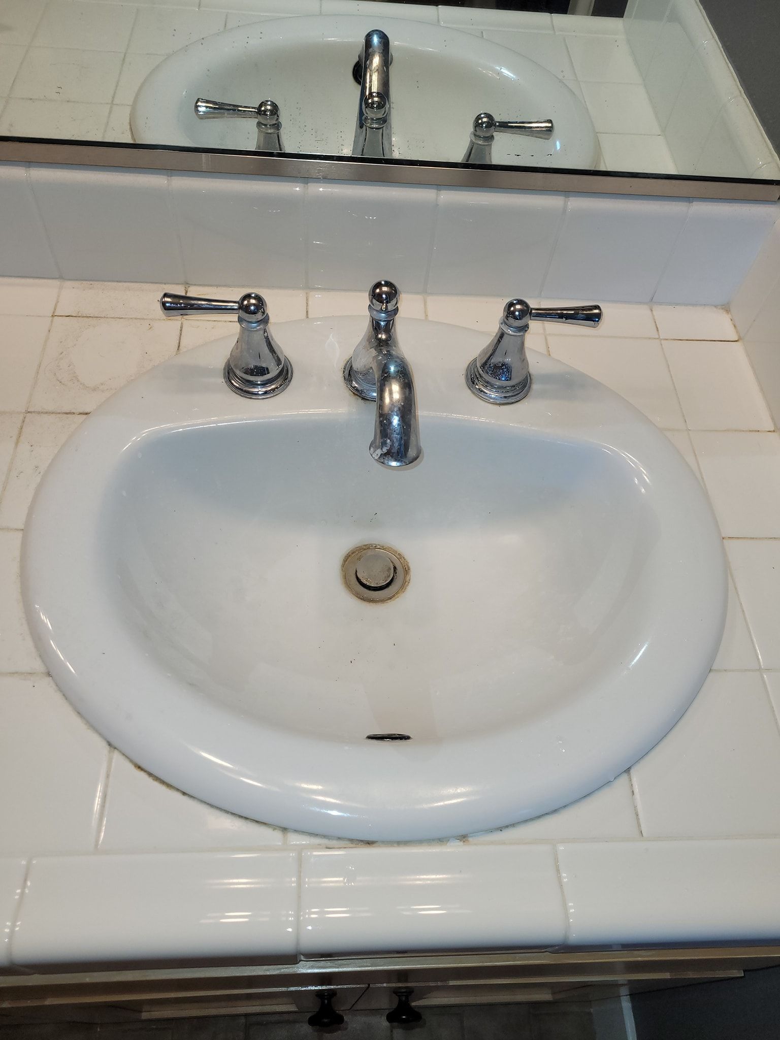 A bathroom sink with a mirror behind it