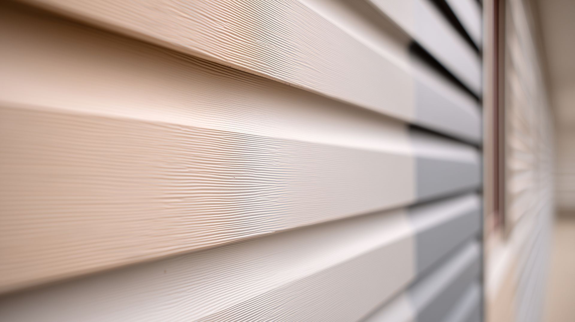 Close-up of off-white vinyl panels during a professional siding replacement project for a home.