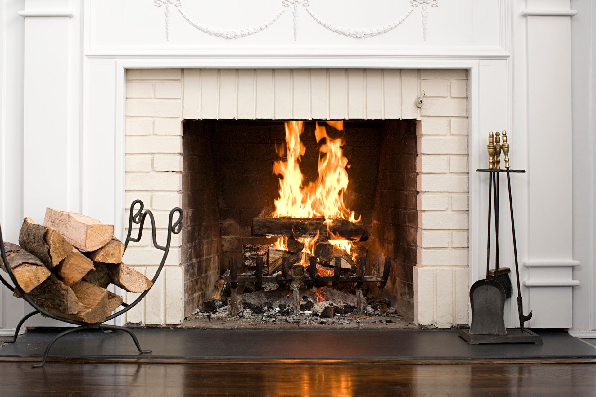 A fireplace with a pile of logs in front of it.