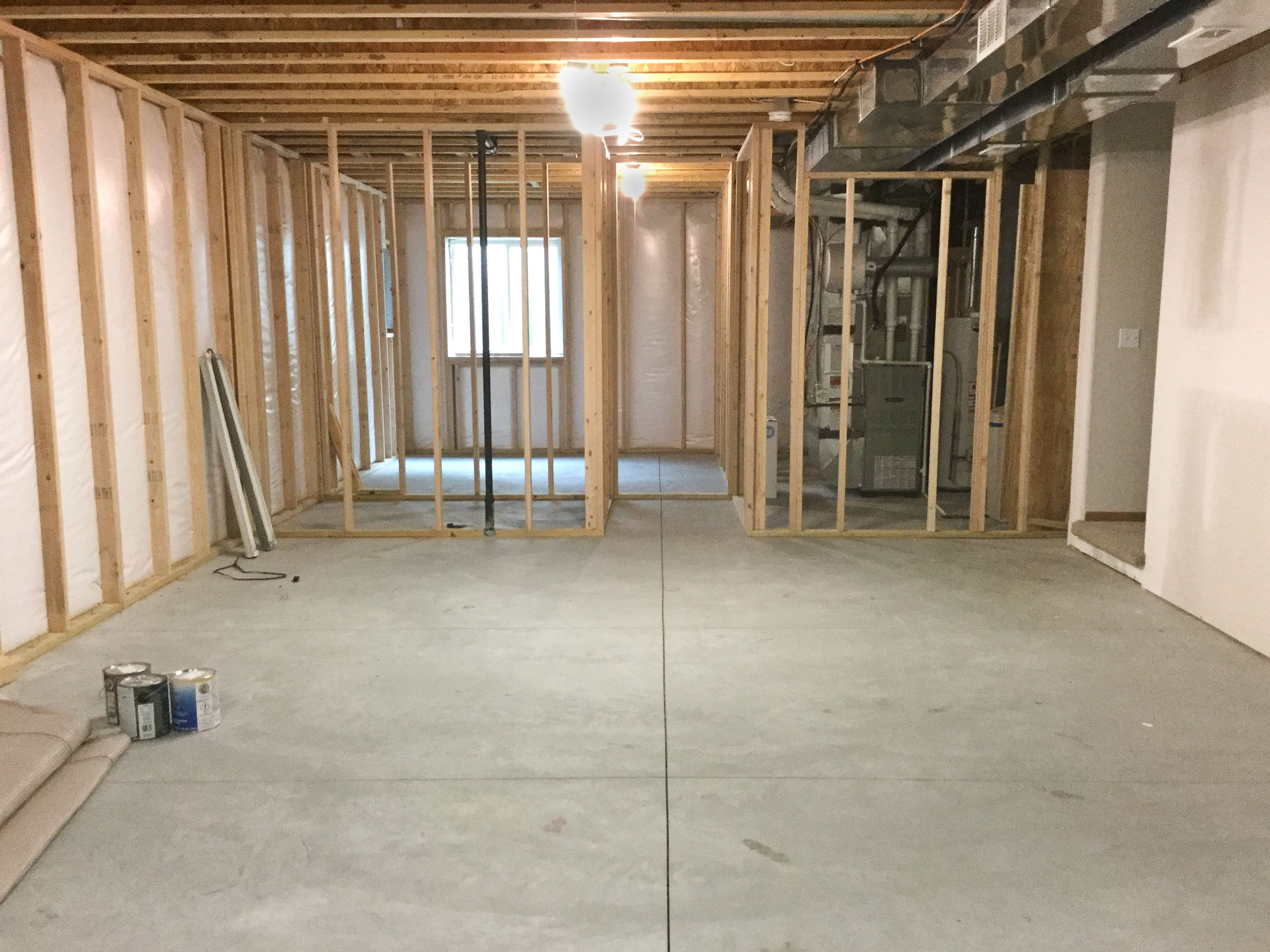 A basement under construction with a concrete floor and wooden walls | Siefken Roofing and Remodeling Services in Omaha, NE