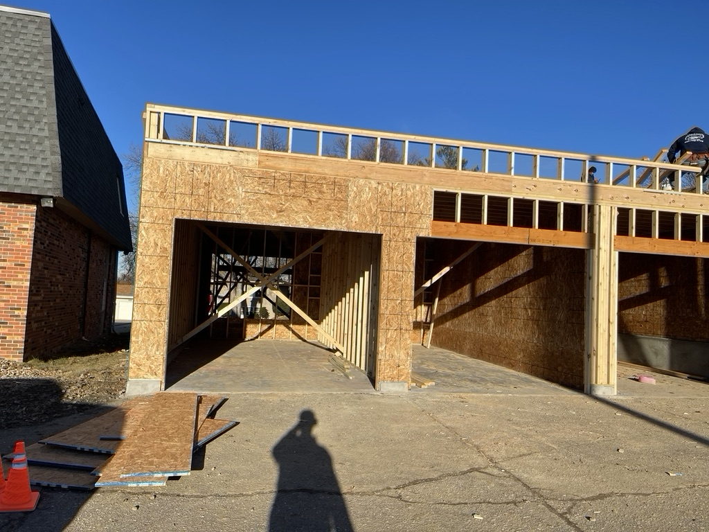A man is working on the roof of a garage under construction | Fire Restoration  Projects | Siefken Roofing and Remodeling Services in Omaha, NE
