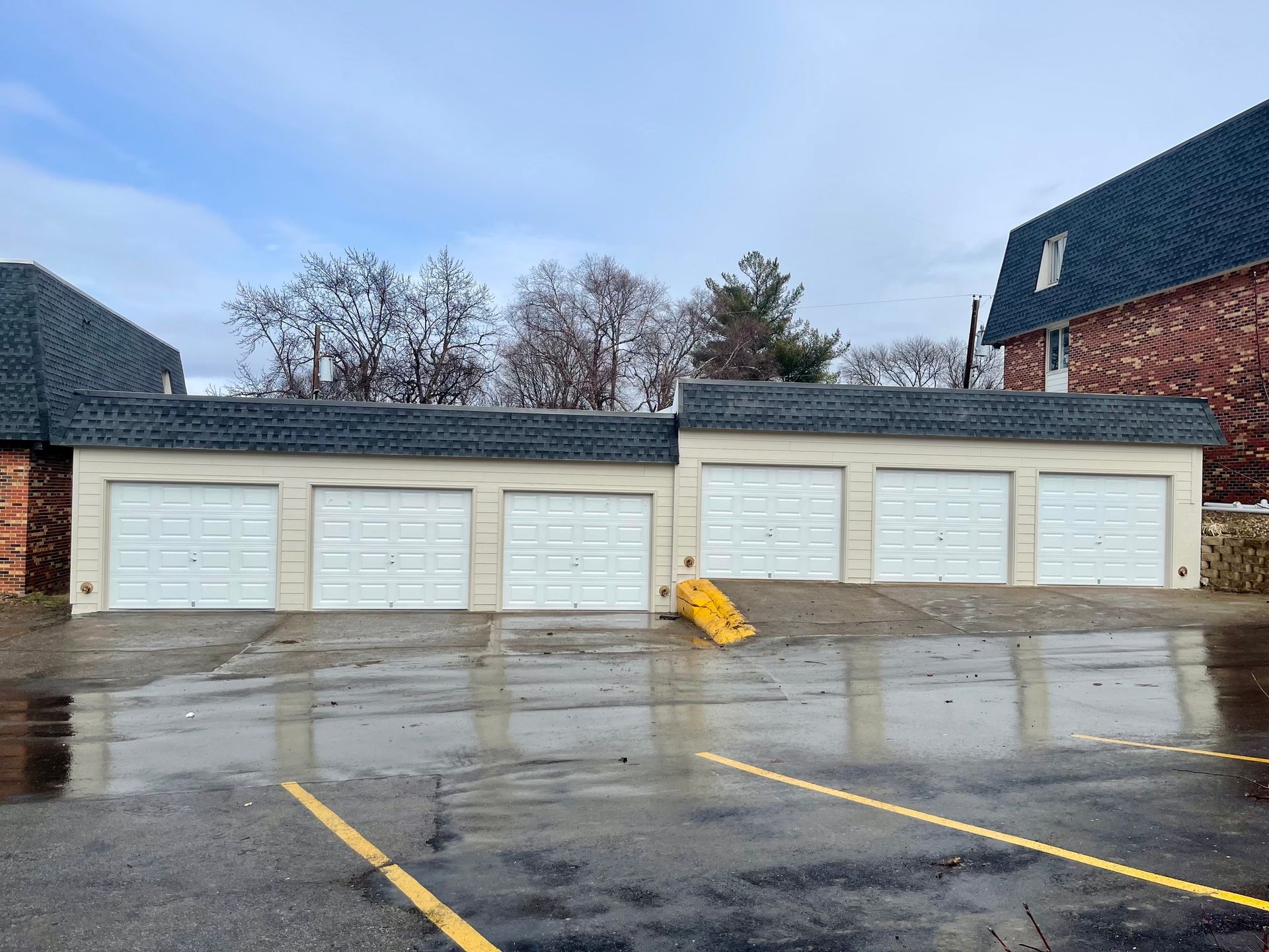 A row of garage doors are lined up in a parking lot  | Fire Restoration  Projects | Siefken Roofing and Remodeling Services in Omaha, NE