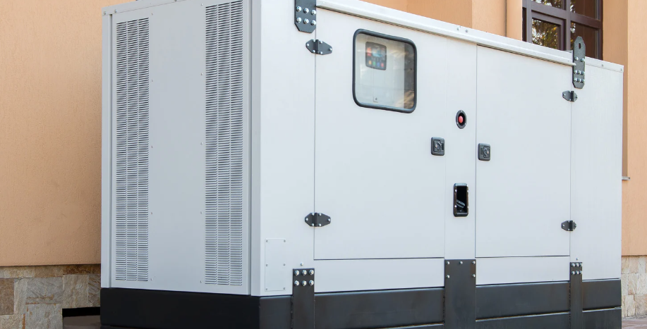 White industrial generator with black base, standing outside, against a beige wall.