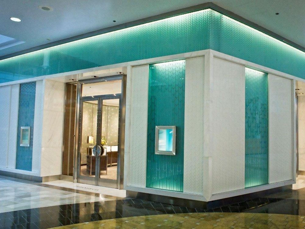 Tiffany & Co. store facade with turquoise and white accents, glass entrance, and a display case.