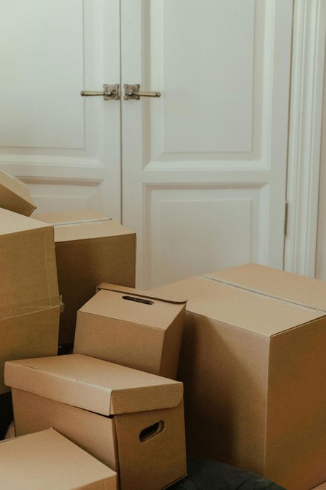 Cardboard boxes stacked near a white door, possibly indicating a move or storage.