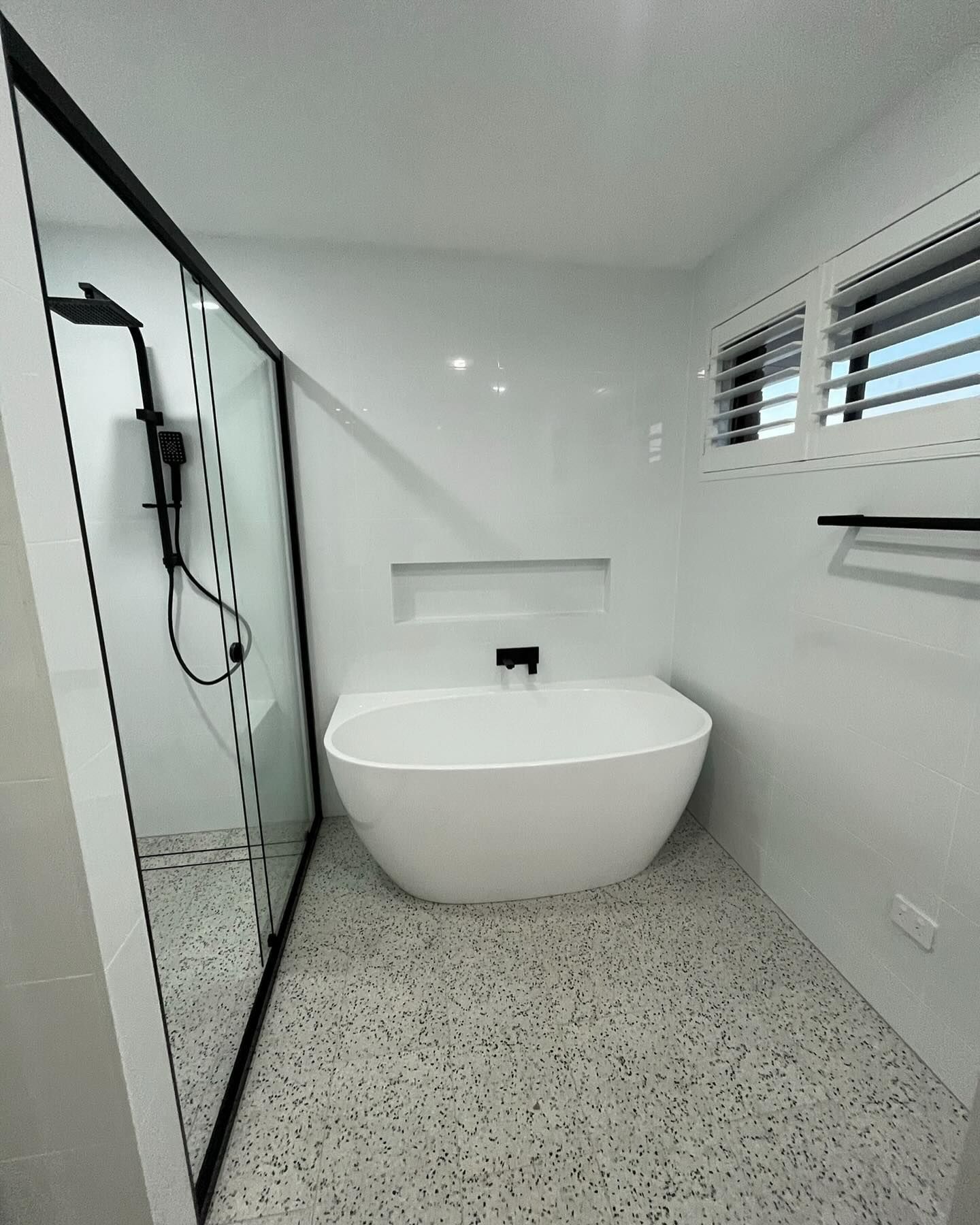 A Modern Bathroom Featuring a White Freestanding Bathtub — Coastbuilt Building Services in Thrumster, NSW