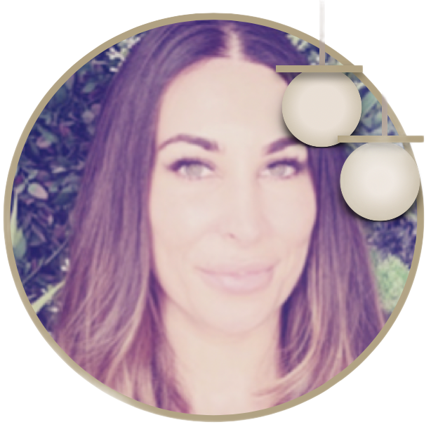 Circular profile photo of a smiling woman with long brown hair, outdoors against greenery.