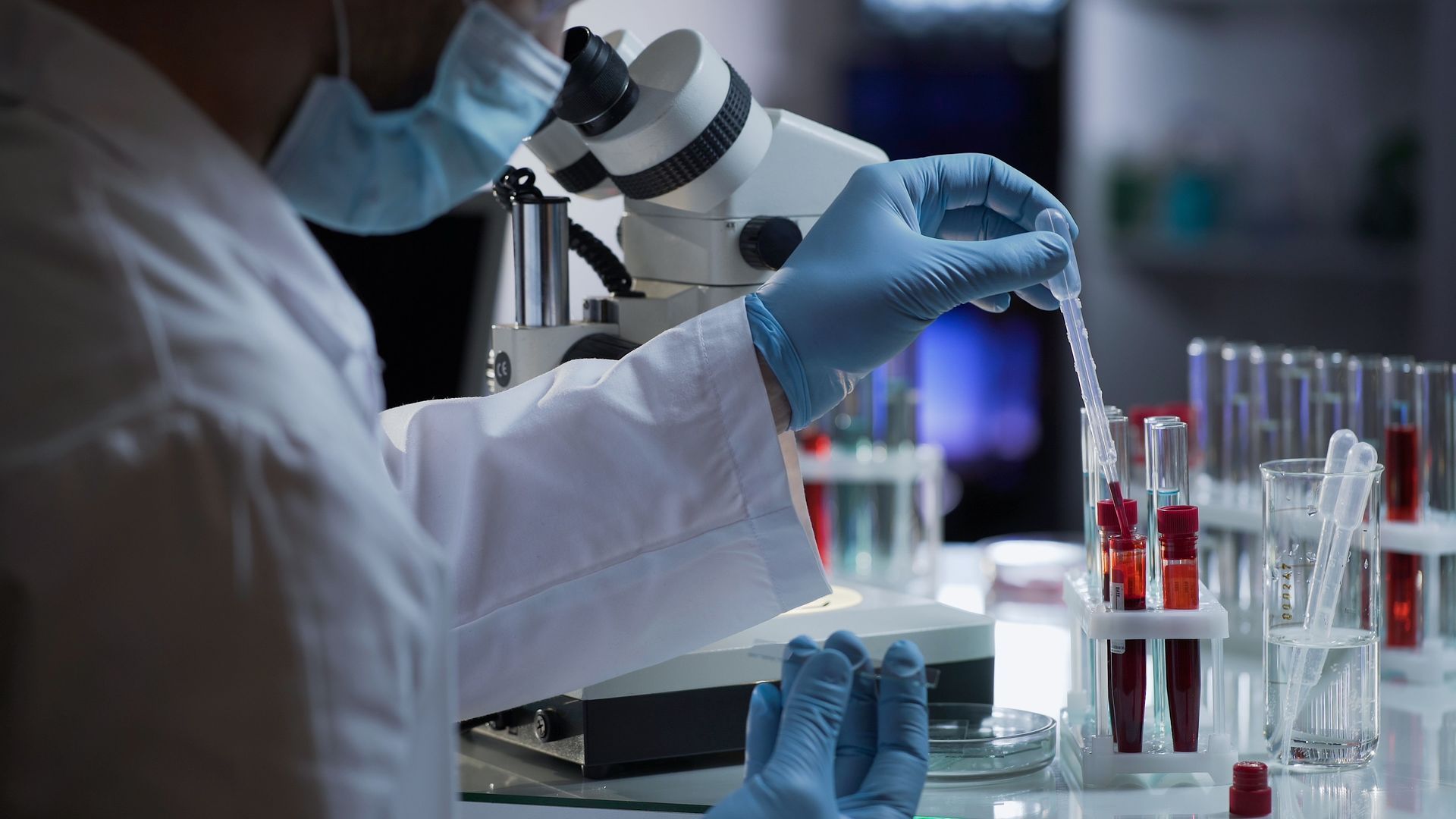 A scientist is looking through a microscope in a laboratory.