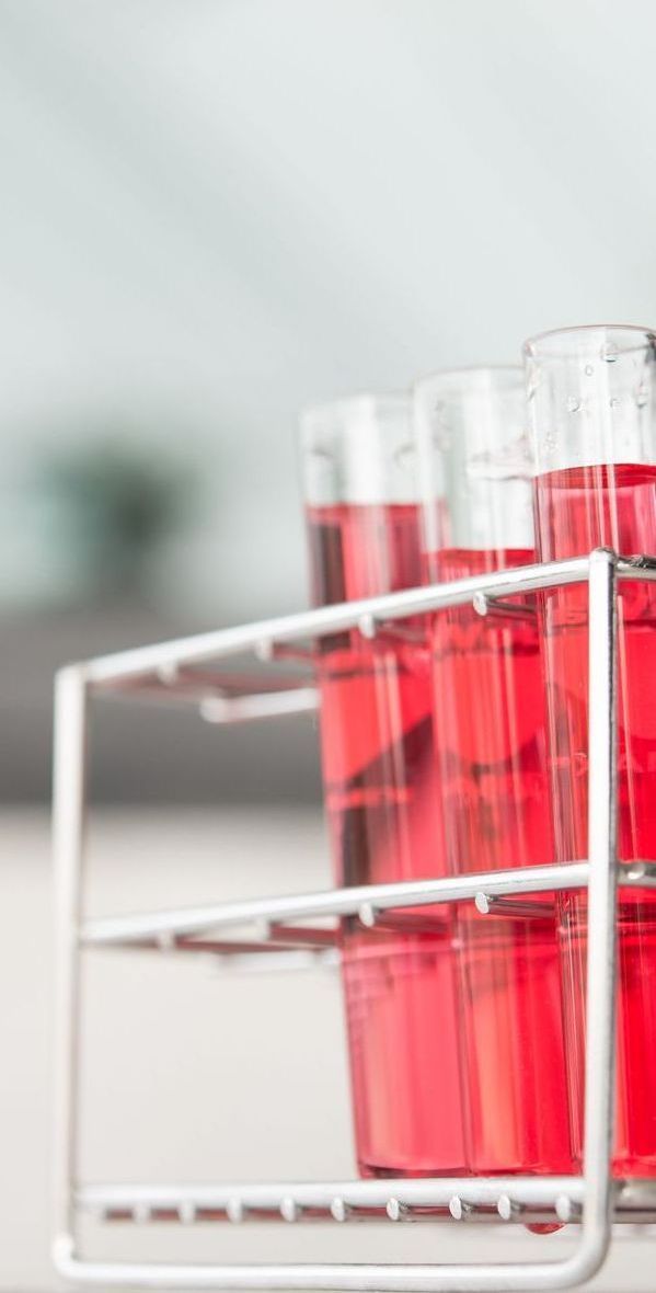 A row of test tubes filled with red liquid in a rack.