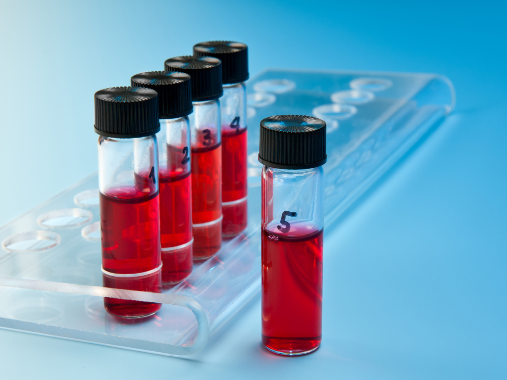 A row of test tubes with red liquid in them