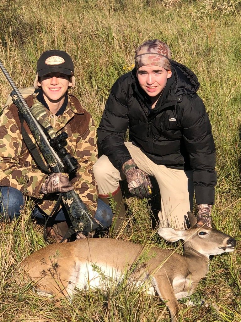 Two People Standing Over Shot Deer