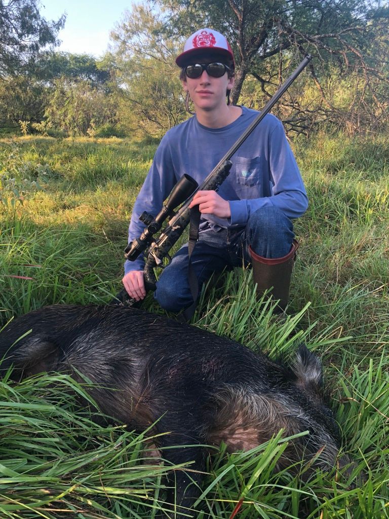 Guy Holding Gun Standing Over Hog