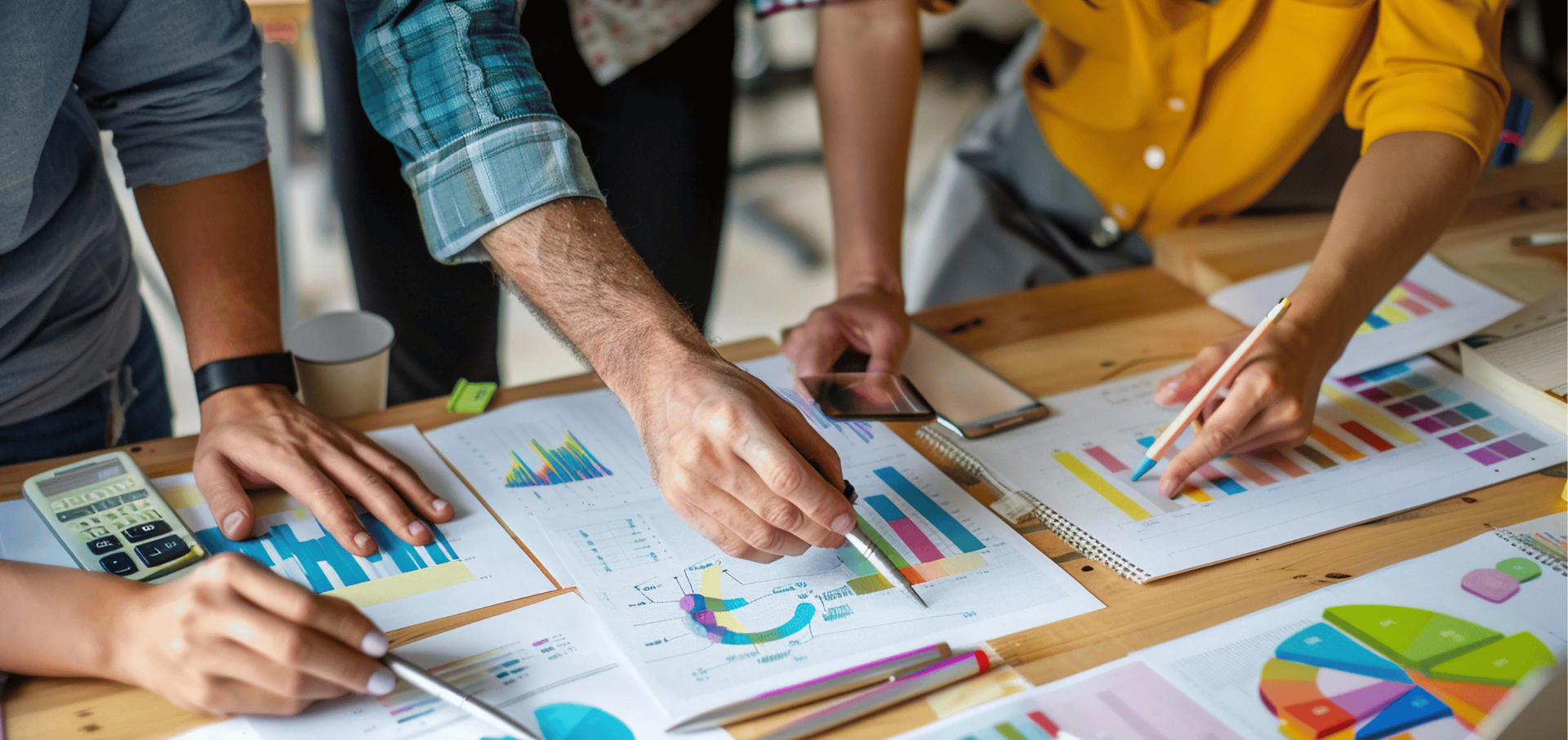 A group of people are sitting at a table looking at graphs and charts.
