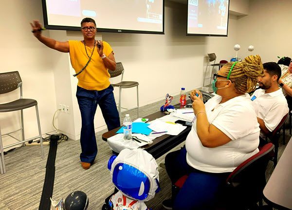 A man is giving a presentation to a group of people in a classroom.