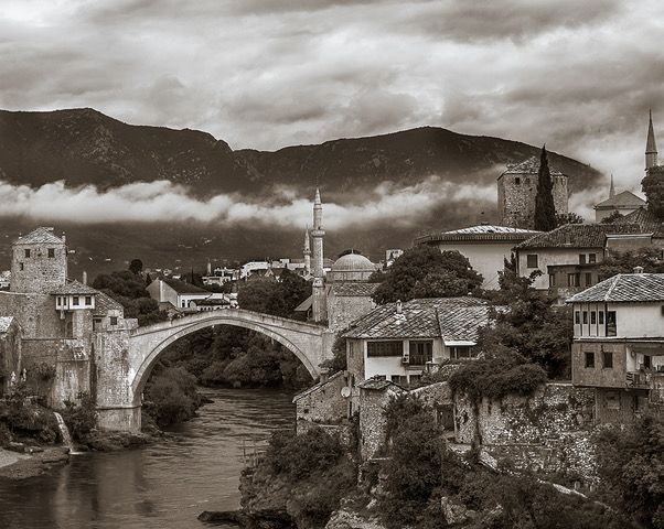 A black and white photo of a bridge over a river