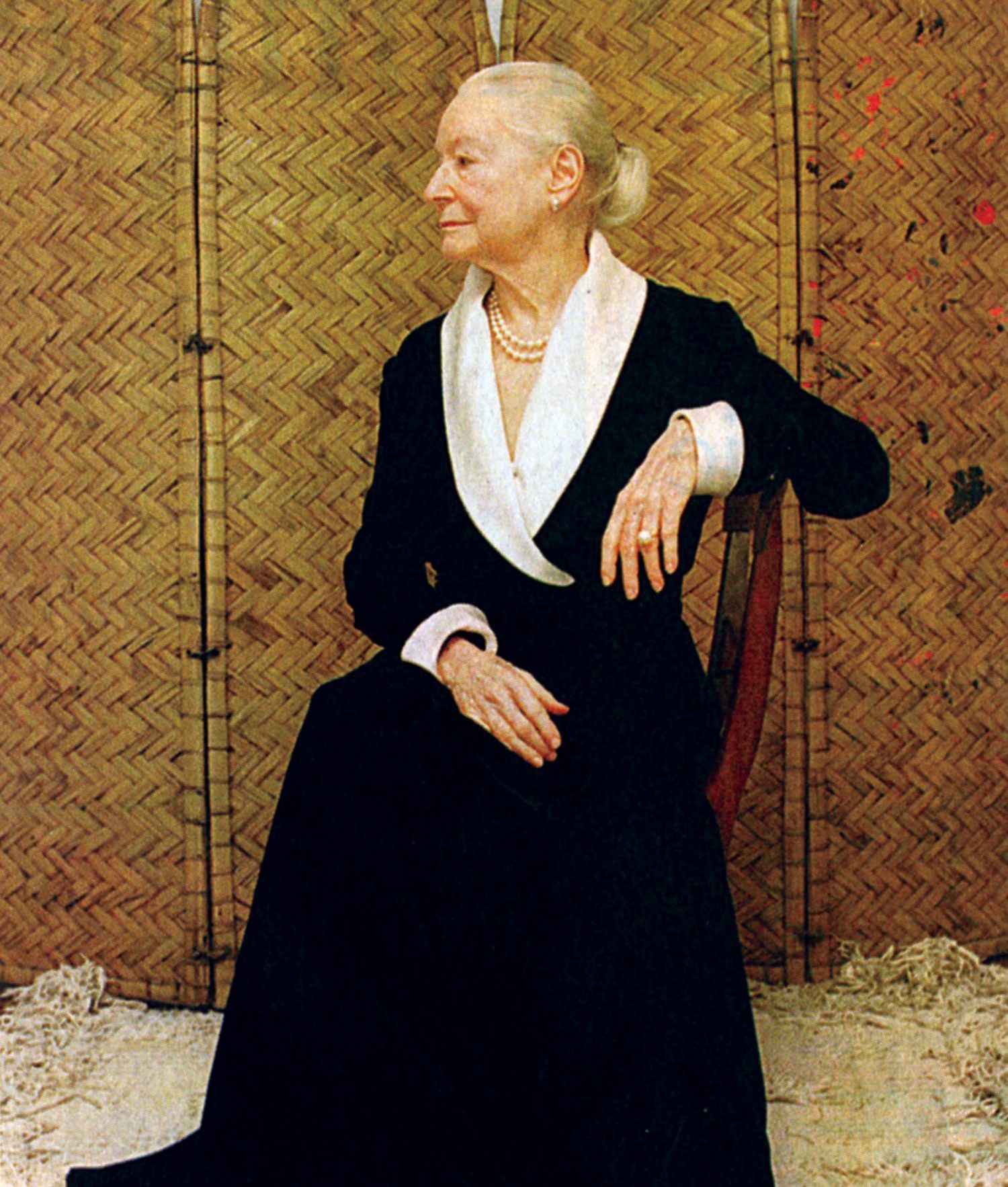 A woman in a black dress is sitting in a chair