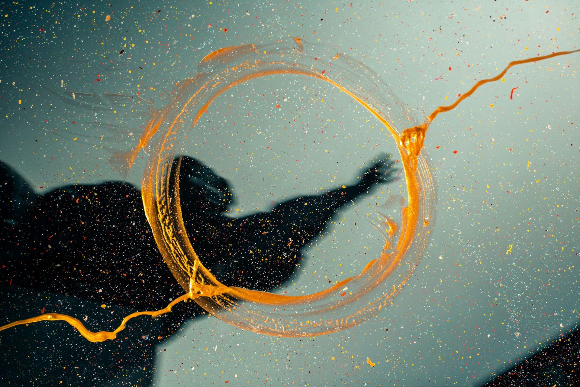 Shadow of a person with gold paint swirling around