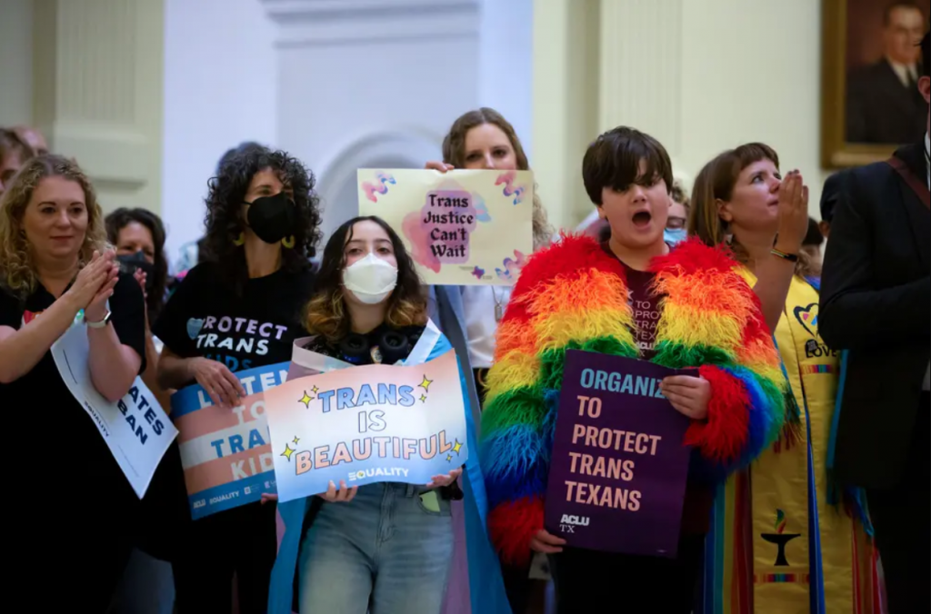 A group of people are standing in a room holding signs.