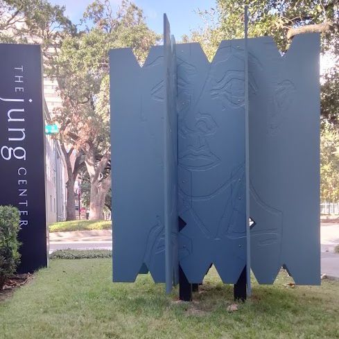 A sign for the jung center sits in the grass