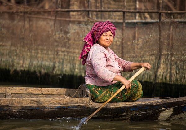 A woman is rowing a boat on a river.