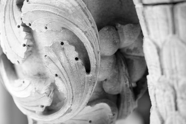 A black and white photo of a sculpture on a wall.