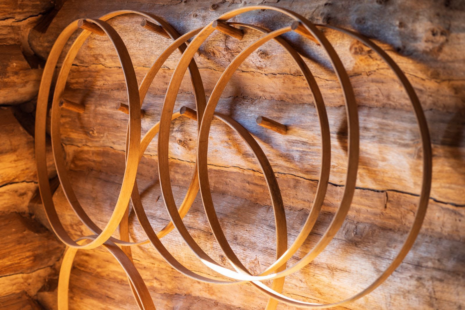 A bunch of wooden rings are stacked on top of each other on a wooden wall.