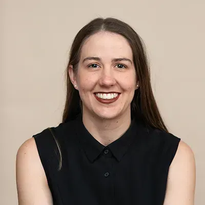 A woman in a black shirt is smiling for the camera.