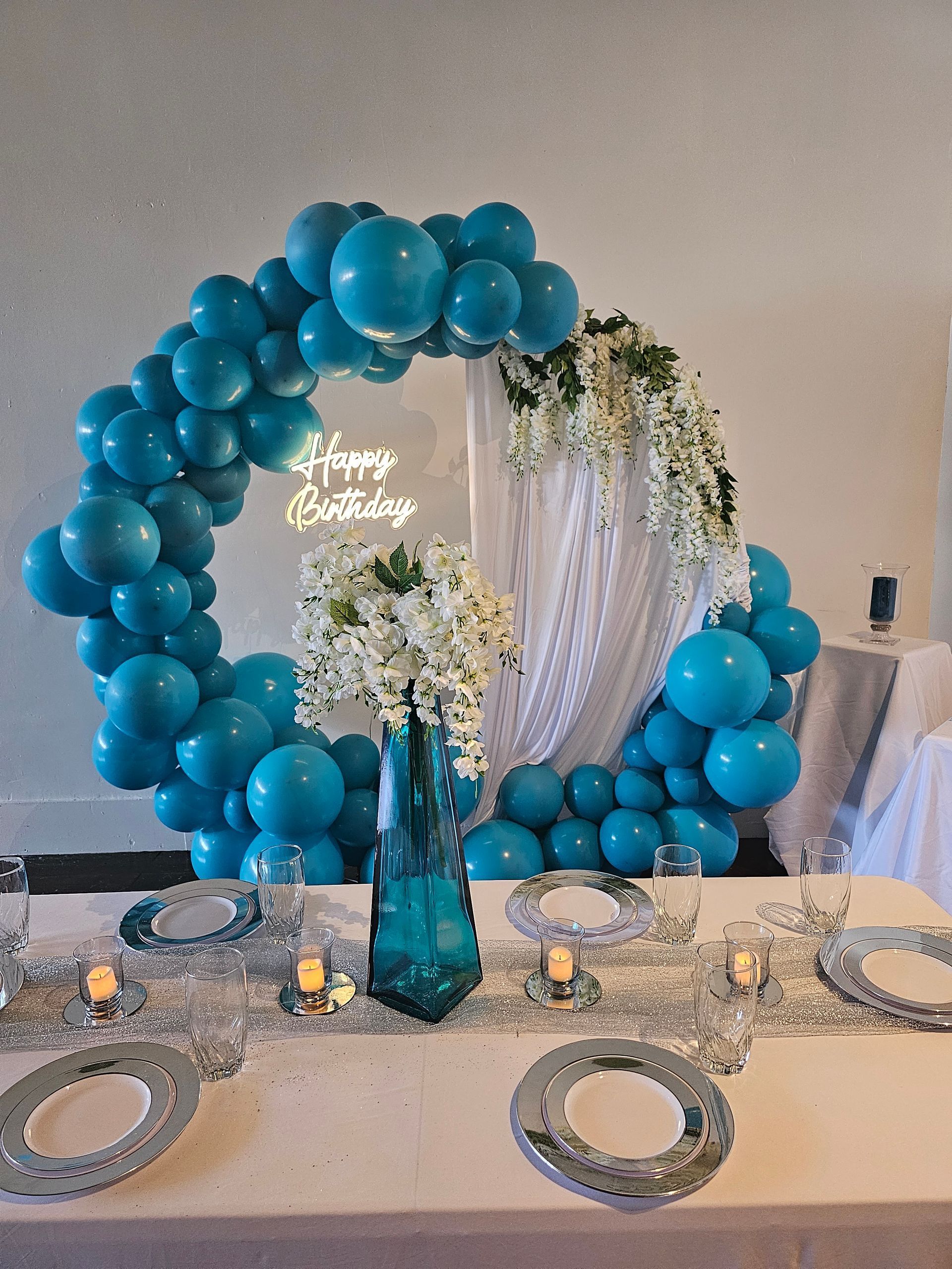 Birthday party setup with blue balloon arch,