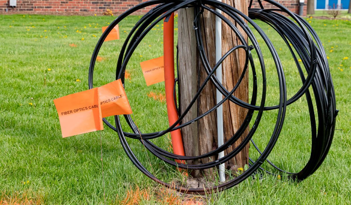 Fiber-Optic-cable-coiled-around-a-telephone-pole-with-lawn-markings