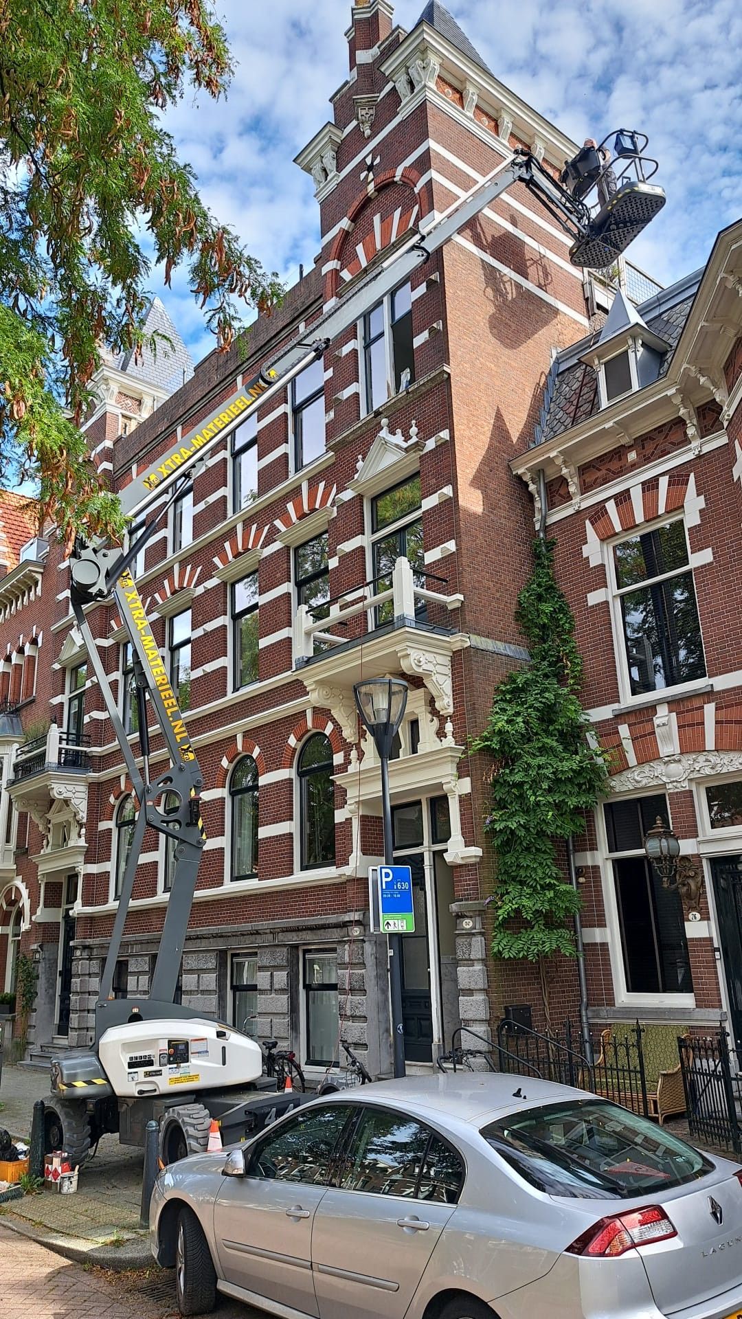 Er staat een auto geparkeerd voor een groot bakstenen gebouw.