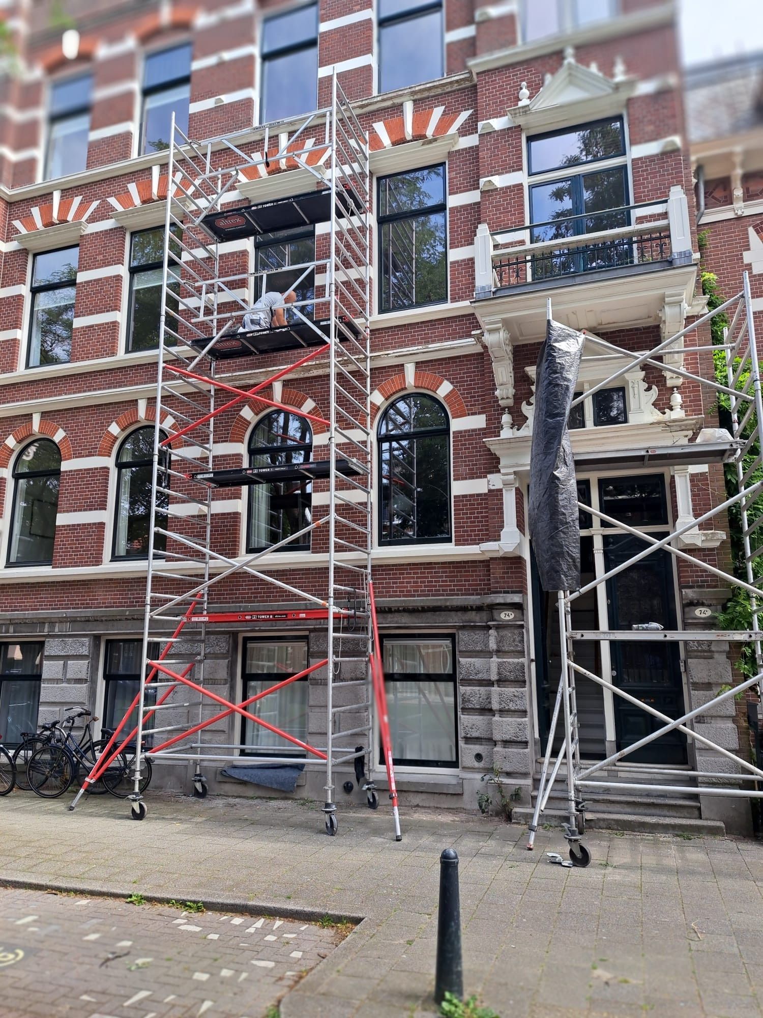 Een groot bakstenen gebouw met steigers ervoor.